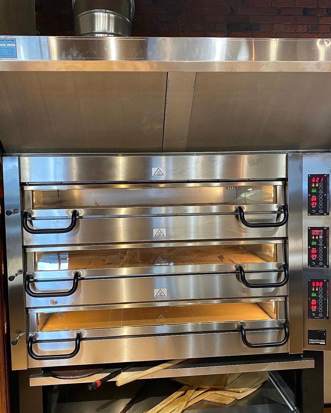 The stainless steel multi-deck pizza oven with its doors open